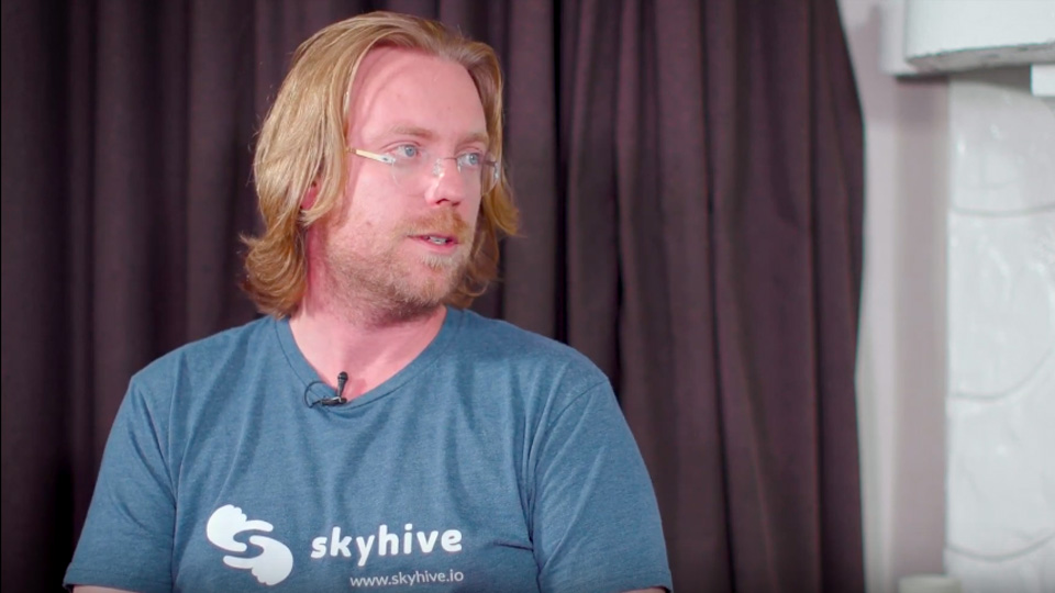 Sean Hinton wearing a skyhive t-shirt,
                                 with his head turned to talk to his interviewer